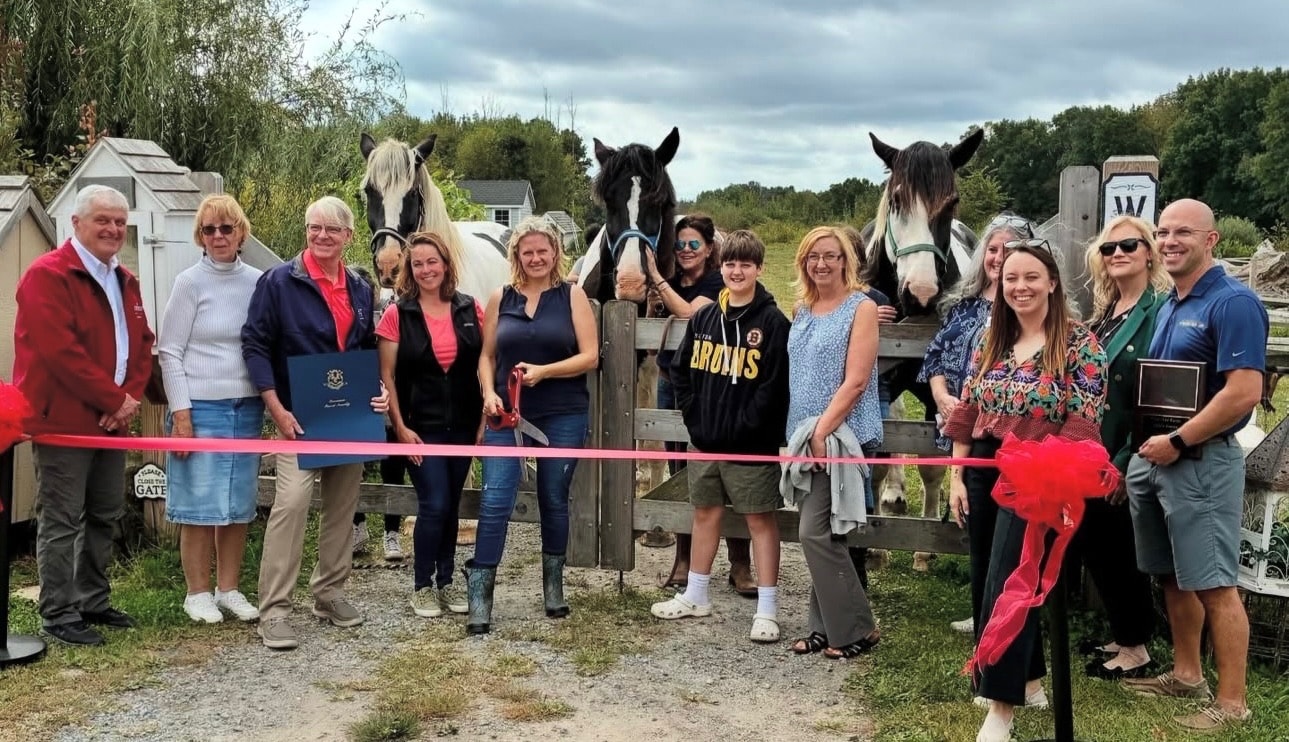 Group cutting ribbon at the Blue Iris Farm opening